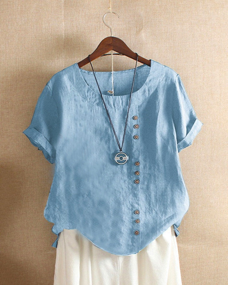 Light blue Beatrice summer blouse with relaxed fit and button details from Lumina Wear, shown on a hanger.