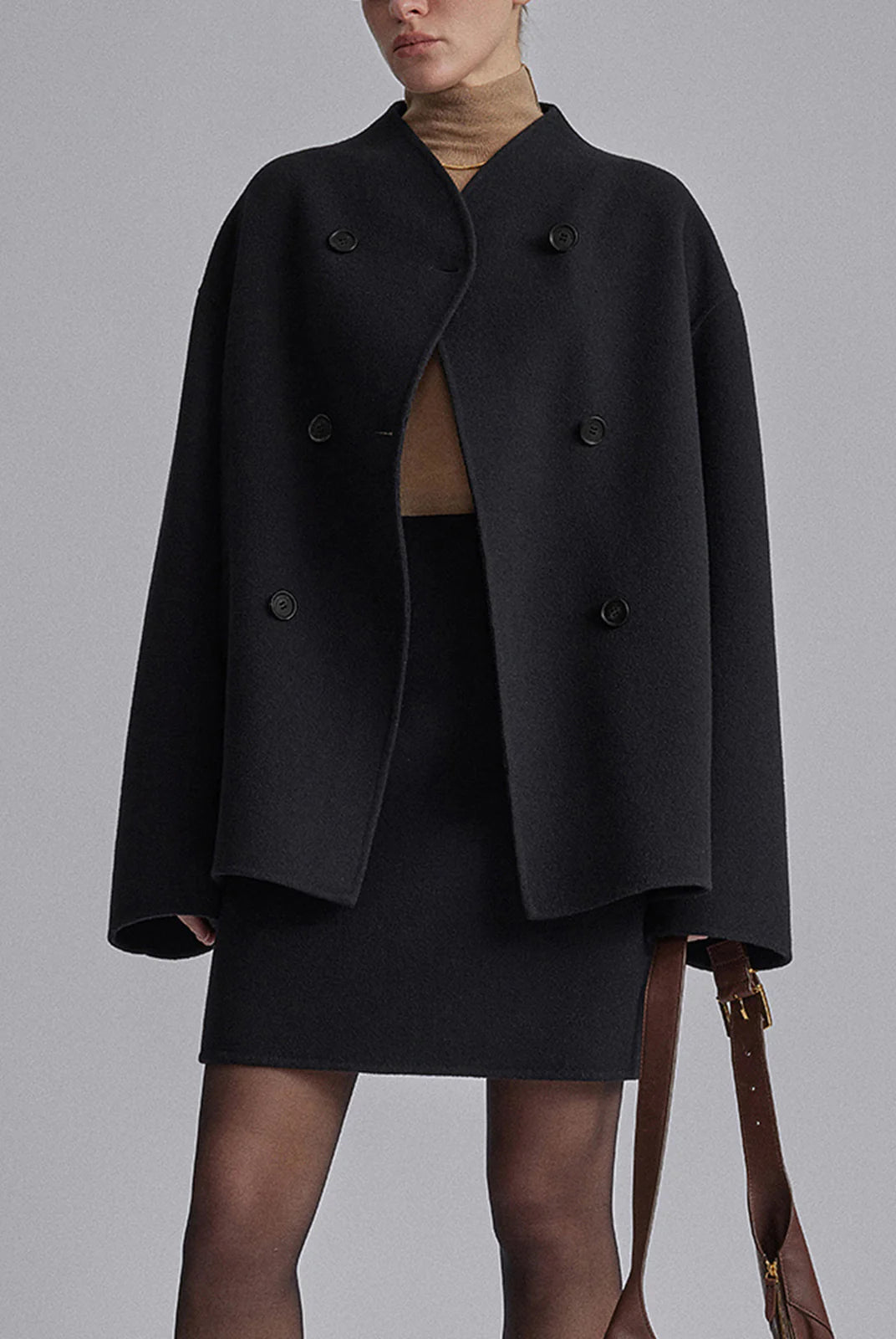 Black Charlene double-breasted peacoat with stand collar by Lumina Wear, shown on a hanger with front buttons and tailored fit.