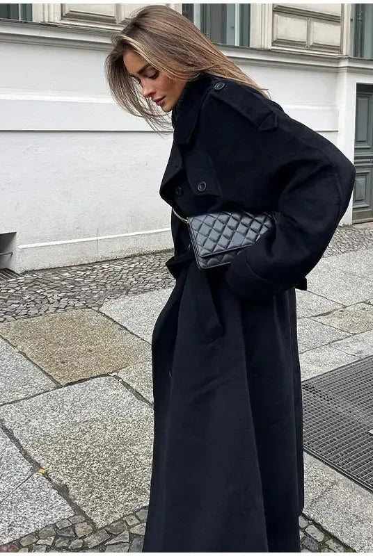 Black double-breasted trench coat with belted waist from Lumina Wear, shown on a model with classic lapels and stylish silhouette.
