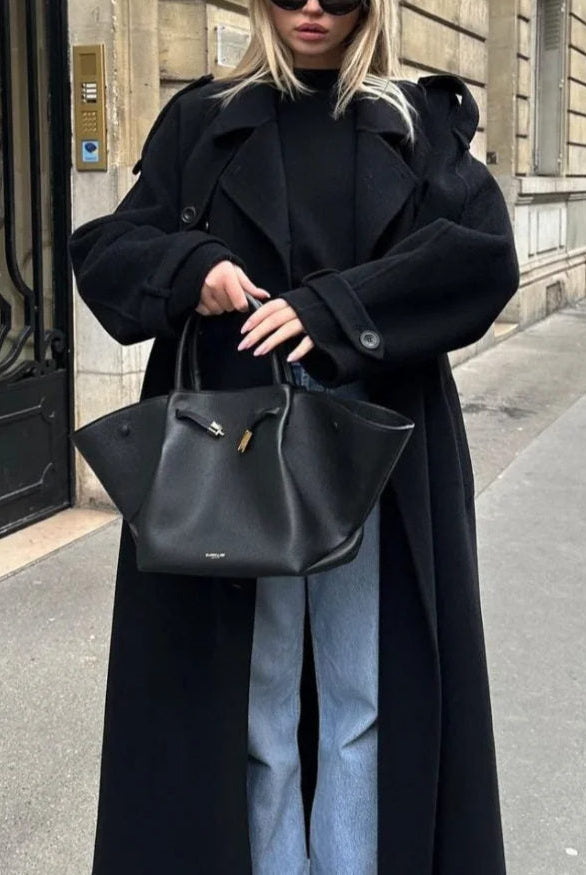 Black double-breasted trench coat with belt at the waist, from Lumina Wear's Cheri collection, shown on a model.
