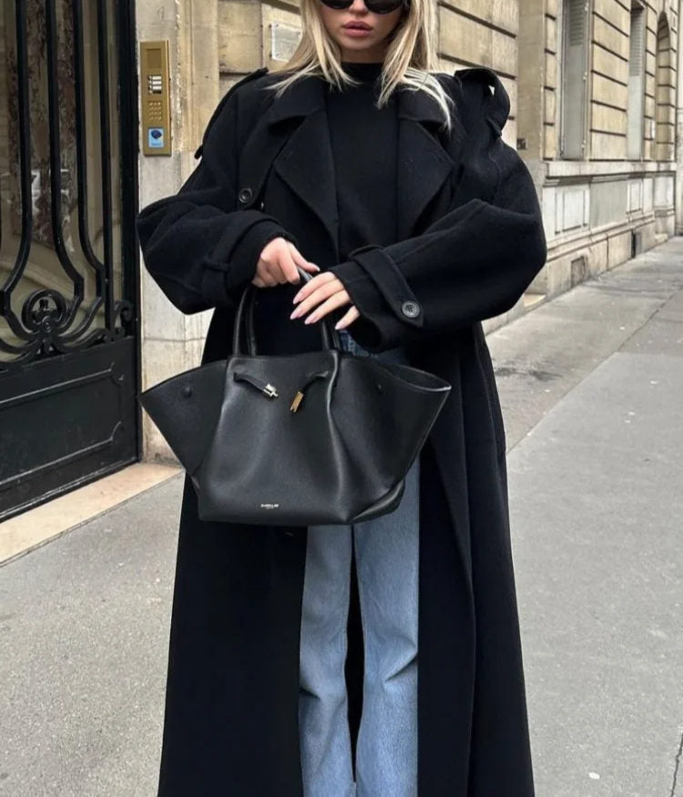 Black double-breasted trench coat with belt at the waist, from Lumina Wear's Cheri collection, shown on a model.