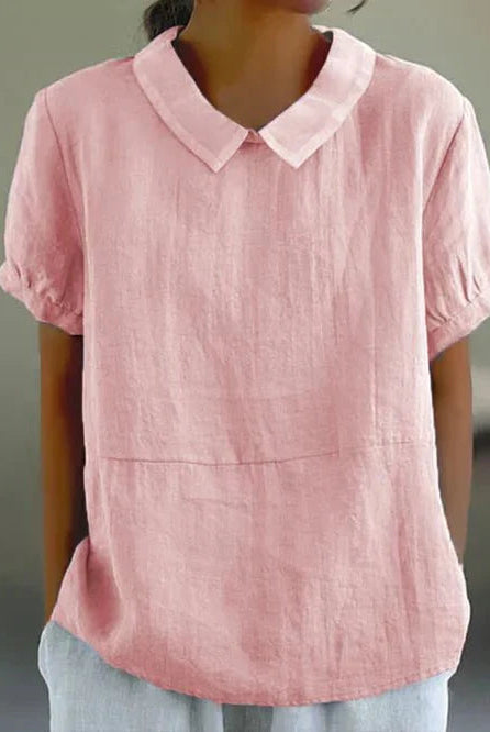 Linen blouse by Lumina Wear featuring a Peter Pan collar and charming design, worn by a model in a casual setting.