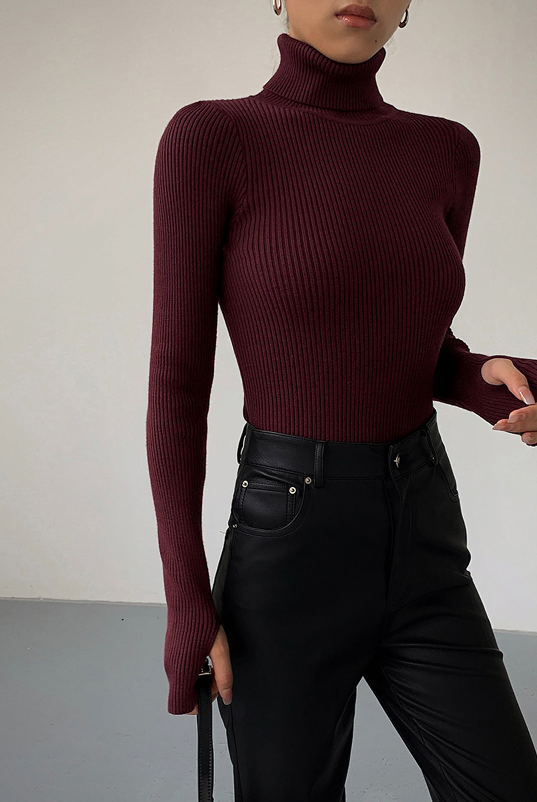 Lumina Wear Hailey sleek minimalist turtleneck top for winter, shown in a close-up of the fitted black turtleneck fabric.