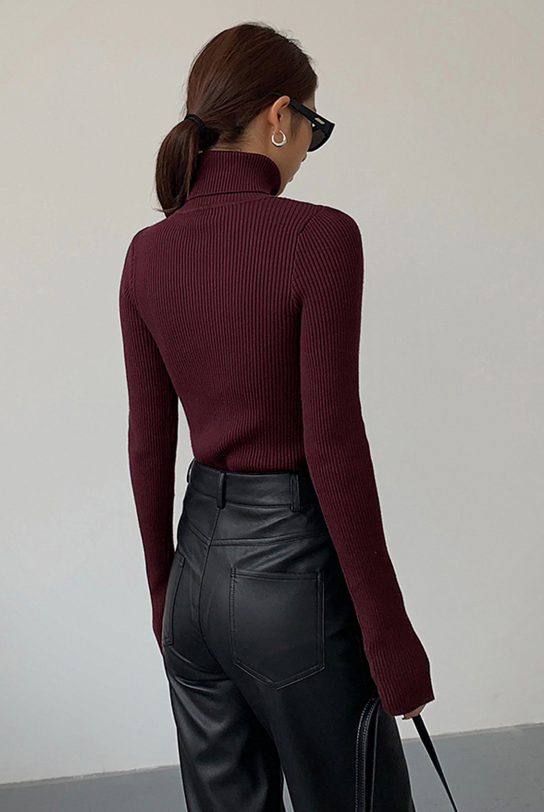 Lumina Wear Hailey sleek minimalist turtleneck top in winter black, showing a close-up of the fitted, smooth fabric and high neckline.