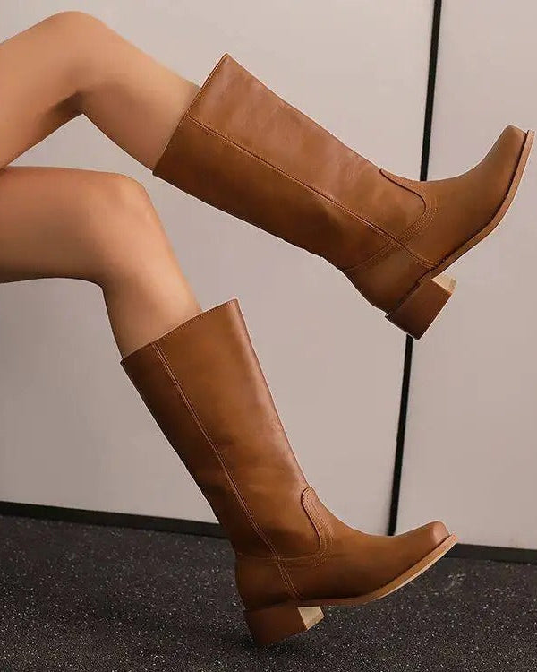 Black knee-high boots with a stacked heel from Lumina Wear's Isabella collection, showing sleek leather and stylish design.