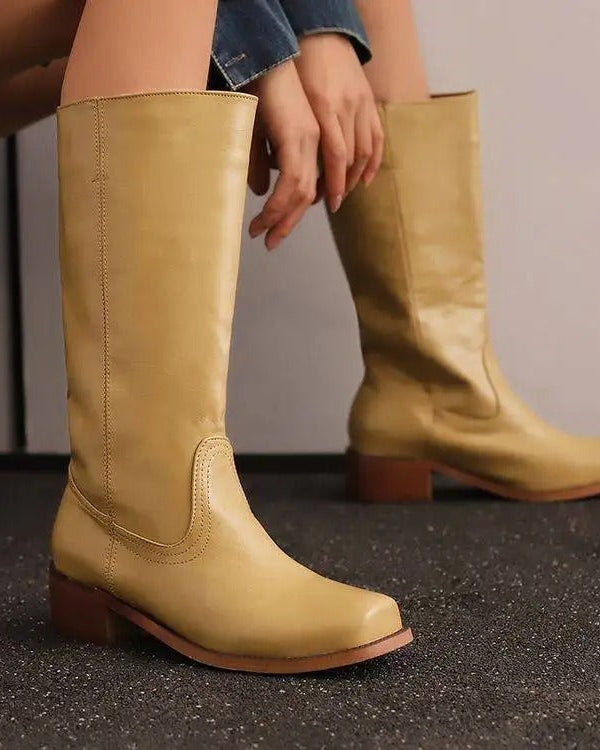 Elegant black knee-high boots with stacked heels by Lumina Wear, showcasing sleek design and stylish ankle-high silhouette.