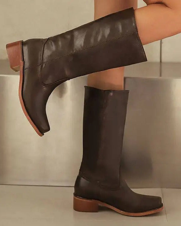 Black knee-high boots with stacked heels from Lumina Wear, featuring a sleek, elegant design and smooth leather finish.