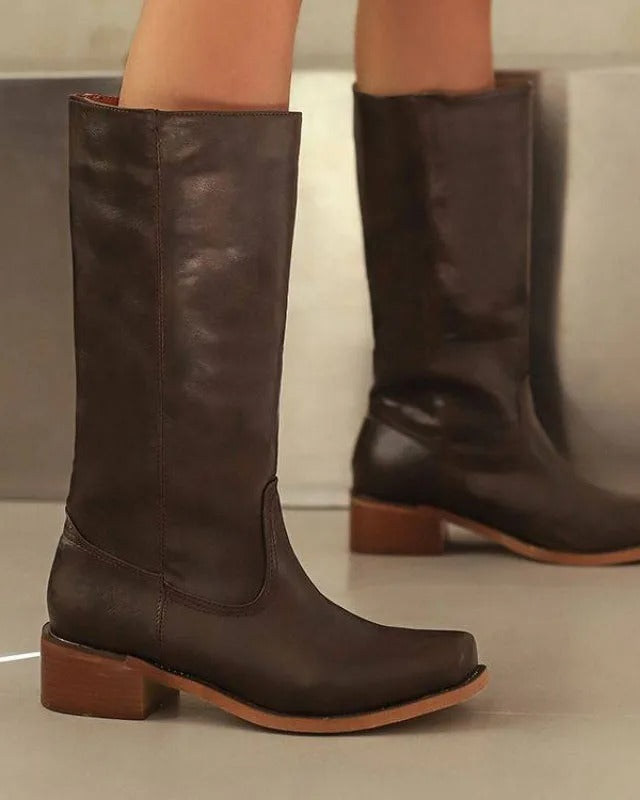 Black knee-high boots with stacked heel from Lumina Wear's Isabella collection, featuring sleek design and stylish silhouette.