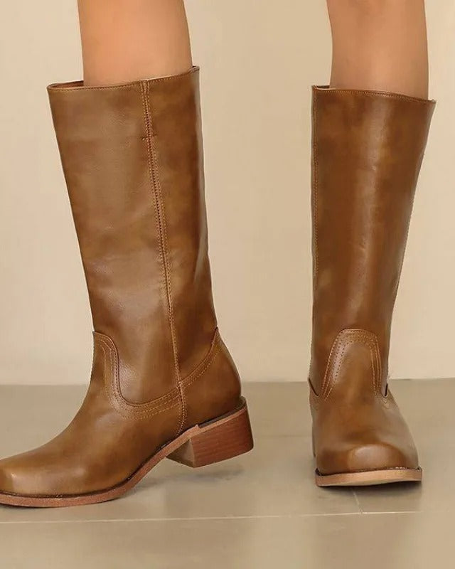 Elegant black knee-high boots with stacked heels from Lumina Wear, featuring a sleek design and smooth leather finish.