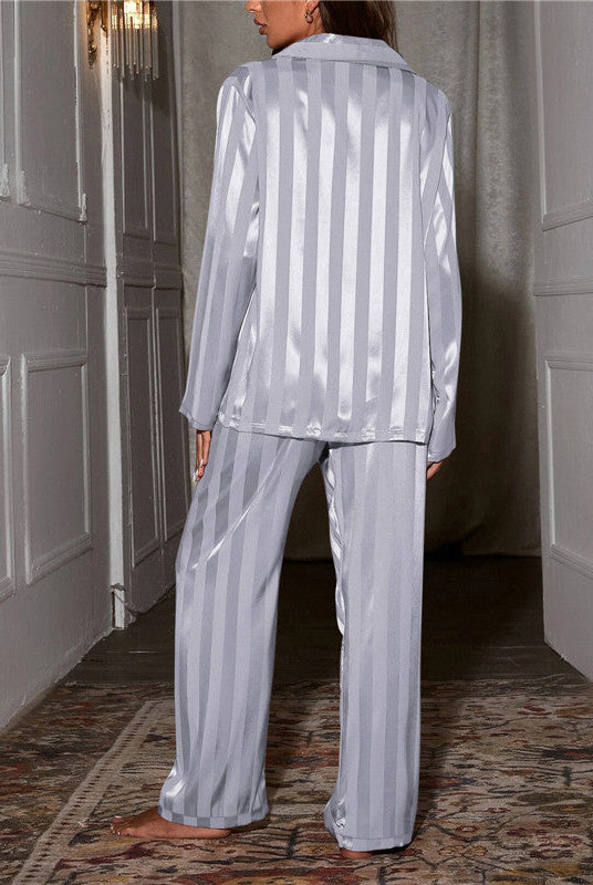 Lumina Wear Ines satin stripe pajama set with button front and wide-leg pants, displayed on a hanger in a stylish bedroom setting.