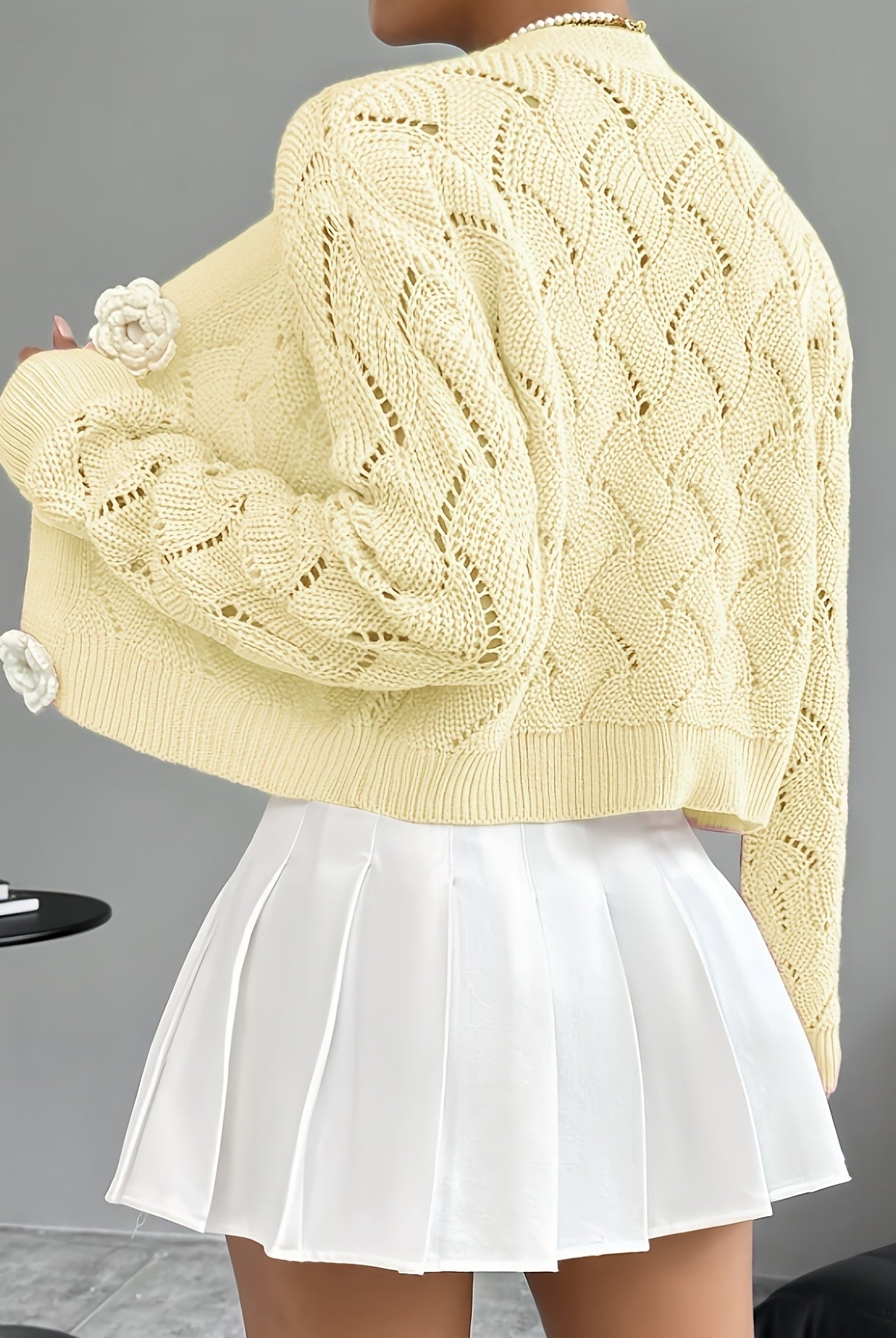 Elegant white crochet cardigan with floral buttons from Lumina Wear, featuring intricate knit details and a stylish, feminine design.