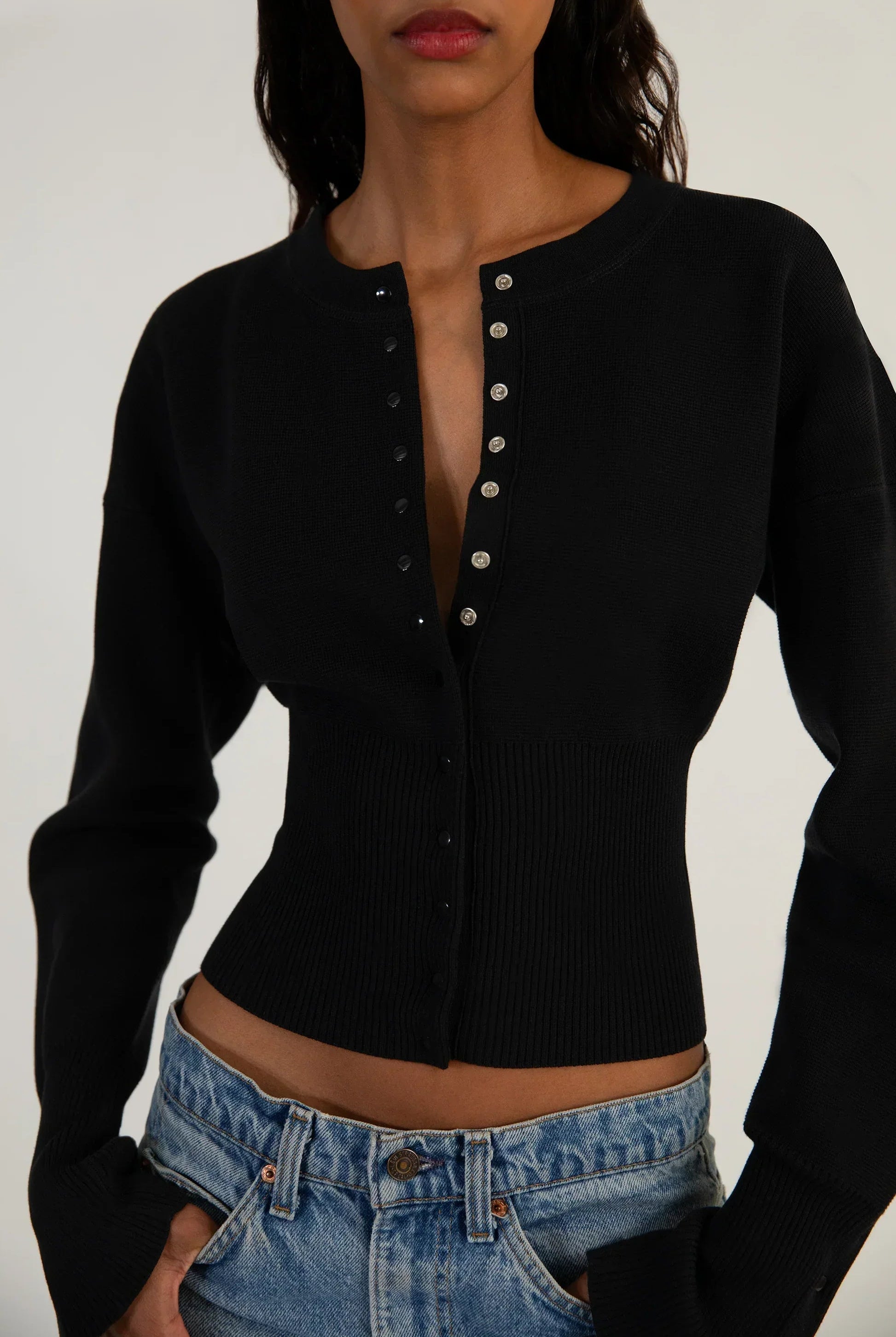 Fitted ribbed cropped cardigan with button closure by Lumina Wear, styled with long sleeves and textured knit fabric.