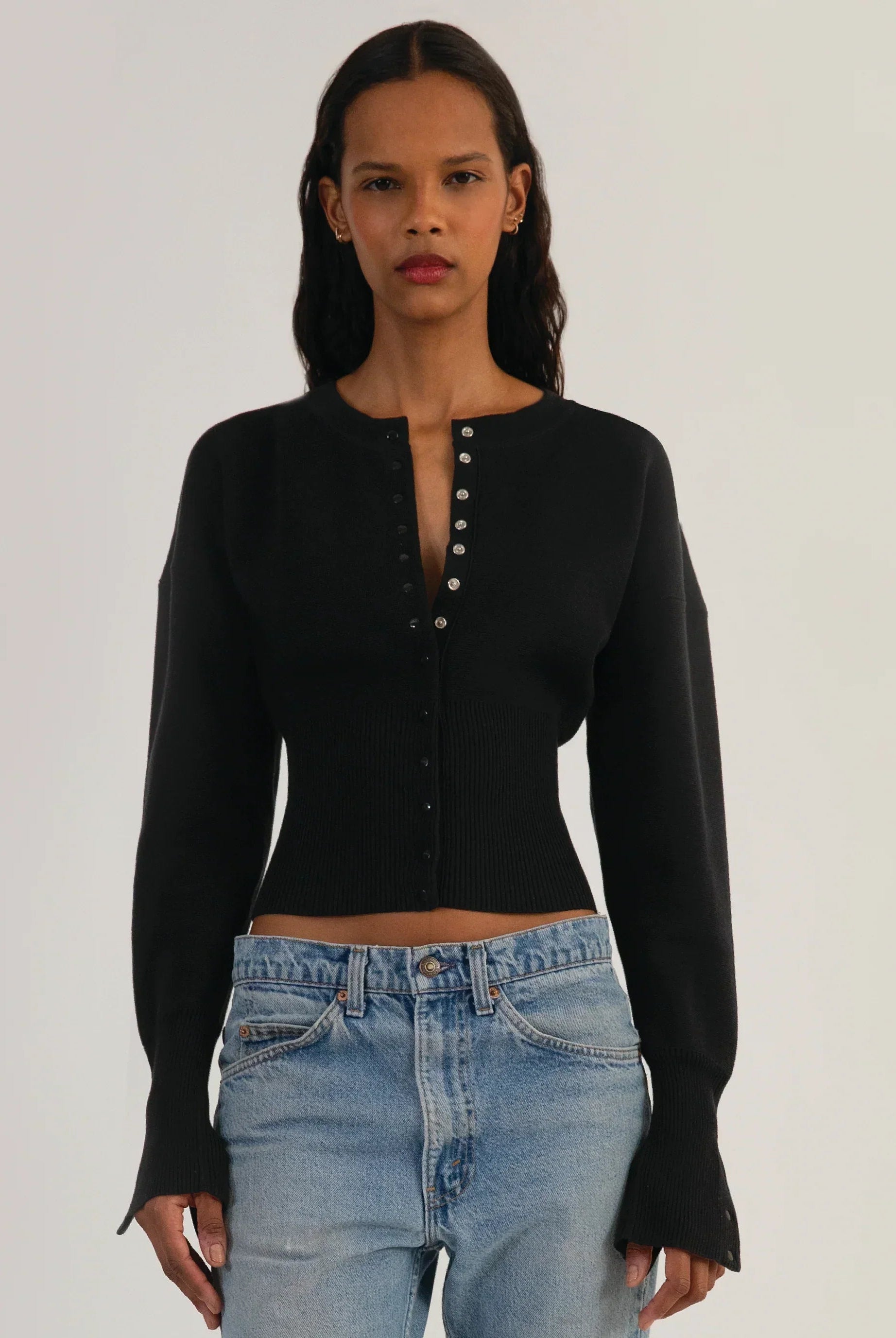 Fitted ribbed cropped cardigan with button closure in neutral color from Lumina Wear's Isabella collection, styled on a model
