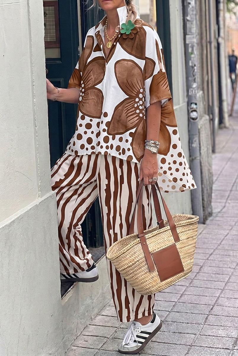 Isabella wearing Lumina Wear's floral polka-dot blouse and high-waisted trousers set, showcasing a stylish and feminine outfit.