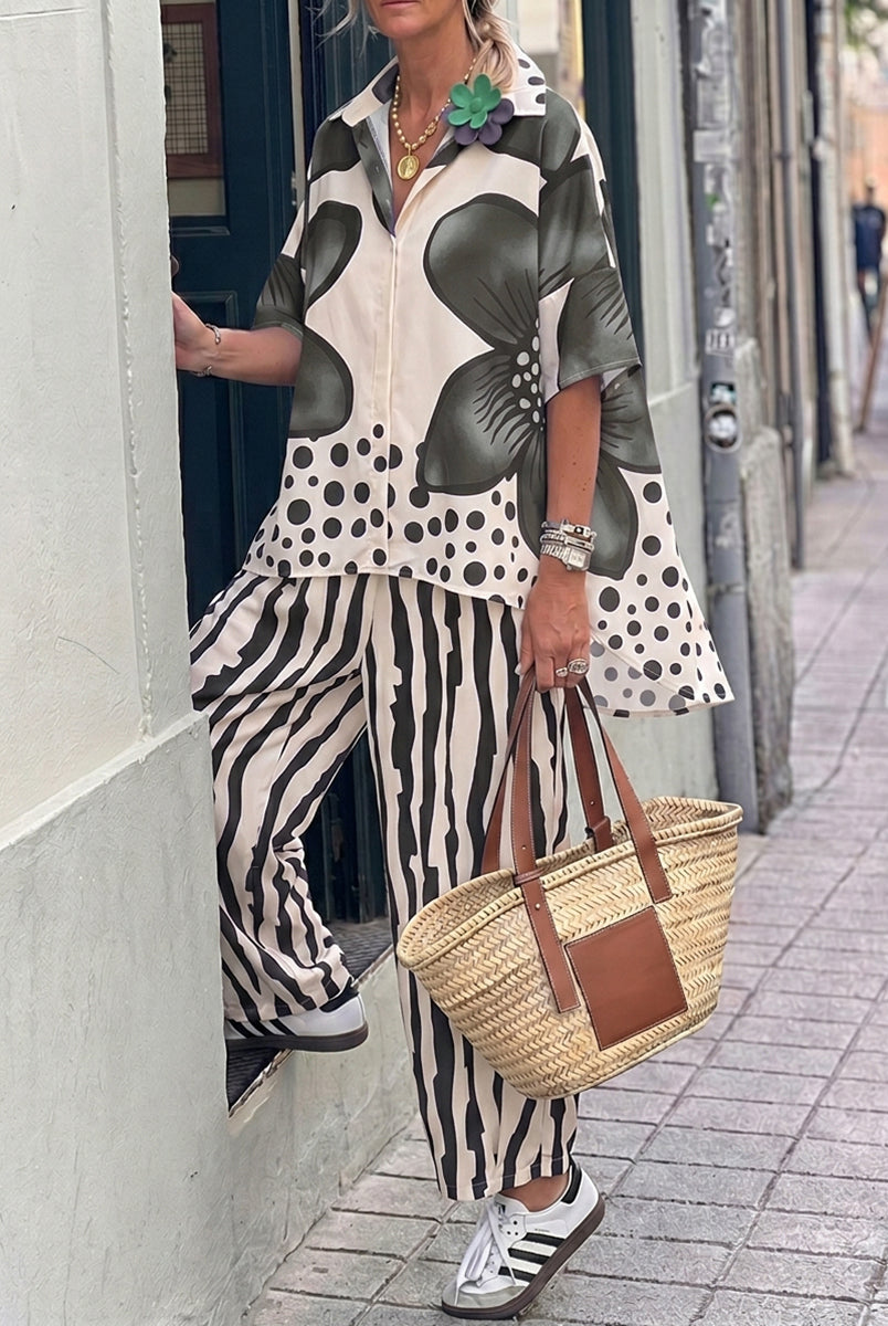 Isabella wearing Lumina Wear's floral polka-dot blouse and high-waisted trousers set featuring a stylish, feminine design.