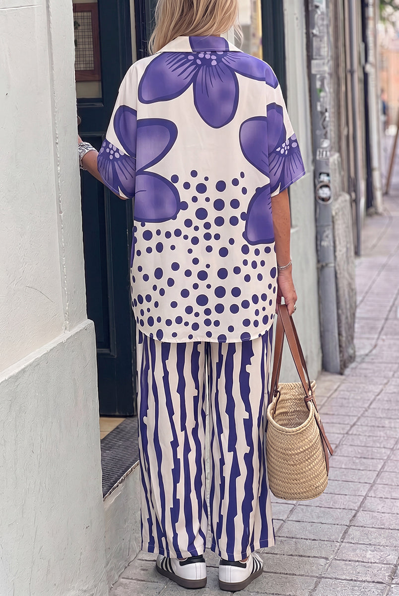 Isabella wearing Lumina Wear's floral polka-dot blouse and high-waisted trousers set, styled with elegant accessories