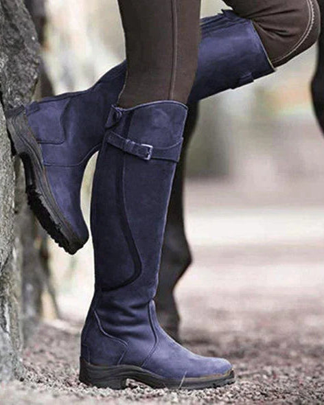 Isabella Lumina knee-high buckle strap boots with ridged sole, featuring stylish design and sturdy construction.
