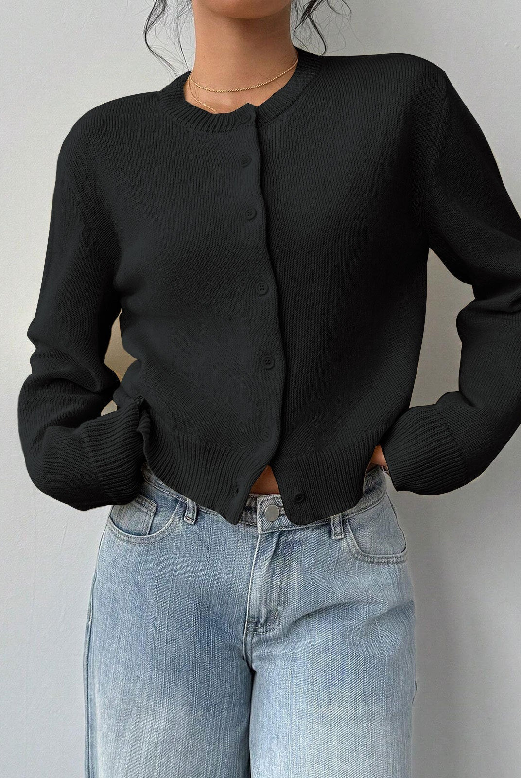 Light-colored Isabella Lumina Wear cropped white cardigan with ribbed trim, relaxed fit, and long sleeves, shown on a model.