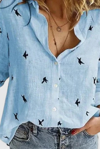 Light blue Isabella Lumina Wear relaxed V-neck blouse with button front, displayed on a hanger.