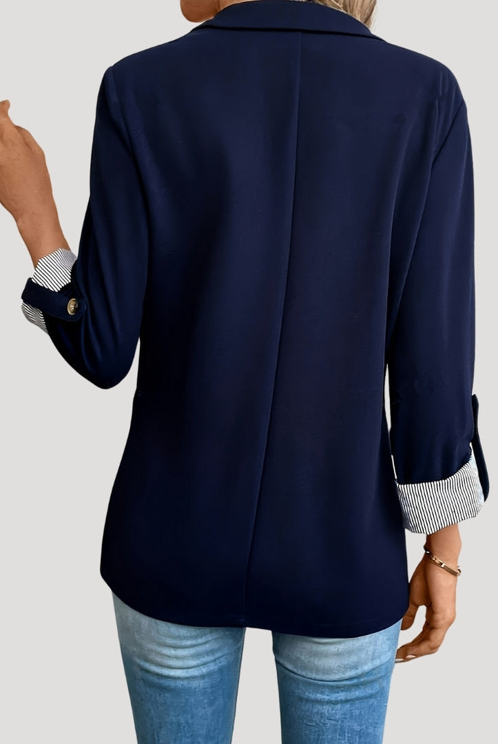 Lumina Wear Isabella tailored blazer with roll-up sleeves and flap pockets, shown on a model in professional setting.