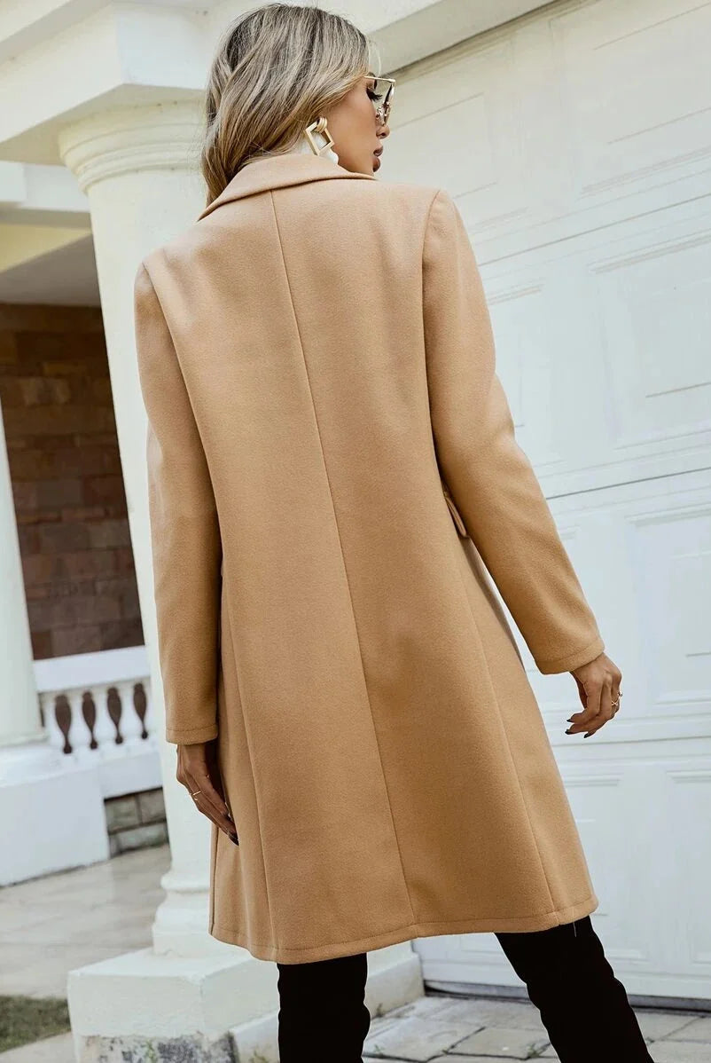 Elegant Isabella Lumina Wear tailored double-breasted knee-length overcoat displayed on a hanger with a classic design and neutral color.