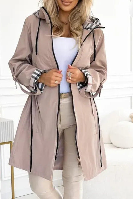 Women's waterproof Isabella parka by Lumina Wear with checked lining and drawstring waist, tailored outerwear for rainy days.