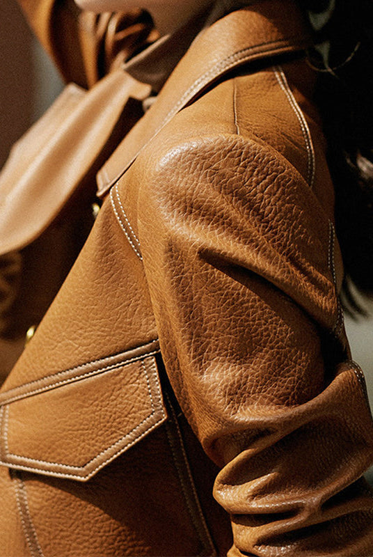 Light brown cropped oversized faux leather jacket with button closure from Lumina Wear, shown on a hanger.