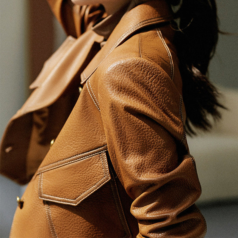Light brown cropped oversized faux leather jacket with button closure from Lumina Wear, shown on a hanger.