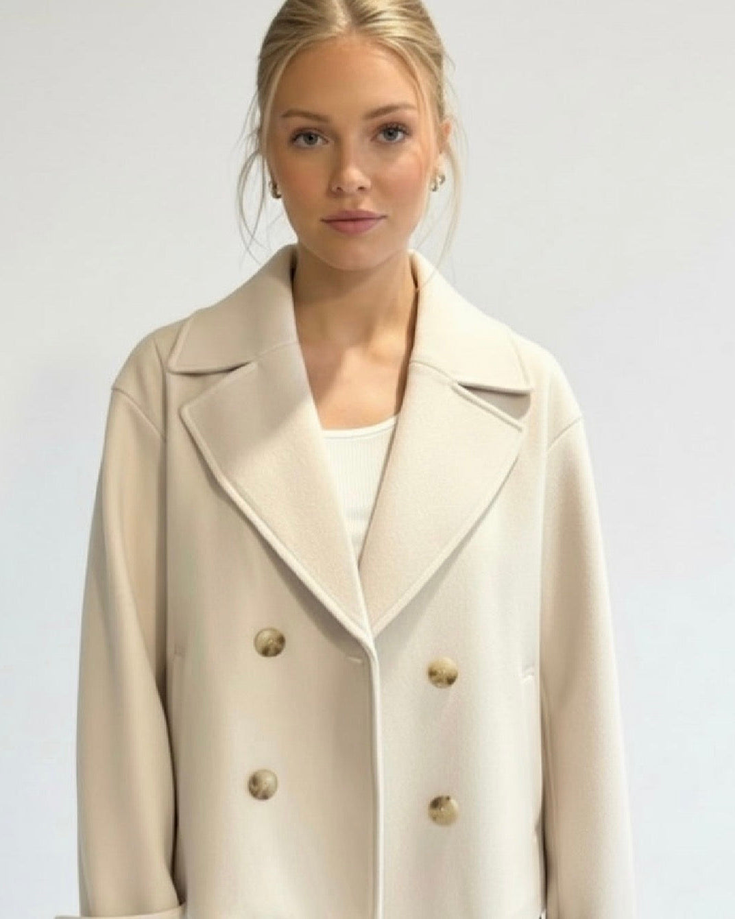 Lumina Wear Maya cropped double-breasted trench coat with structured shoulders, shown on model with neutral background.