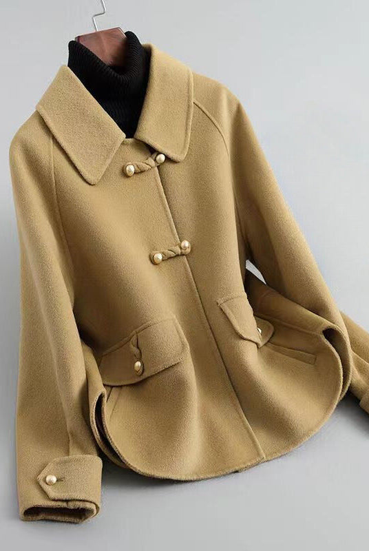 Elegant knit coat by Lumina Wear featuring pearl buttons and a distinctive collar, stylishly worn by a model.