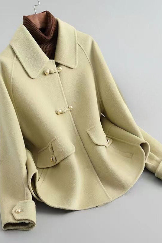 Elegant knit coat by Lumina Wear featuring pearl buttons and a distinctive collar, showcased in a stylish front view.