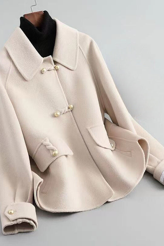 Elegant Lumina Wear Sofia knit coat with pearl buttons and a distinctive collar, showcasing a stylish and cozy outerwear piece.
