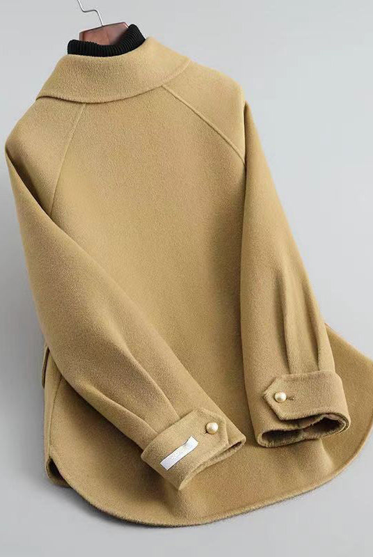 Elegant Lumina Wear Sofia knit coat with pearl buttons and a distinctive collar, shown in a stylish, close-up view.