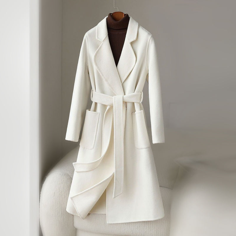 Elegant monochrome wool coat with waist belt from Lumina Wear, shown in a stylish women's coat with a tailored fit and classic design.