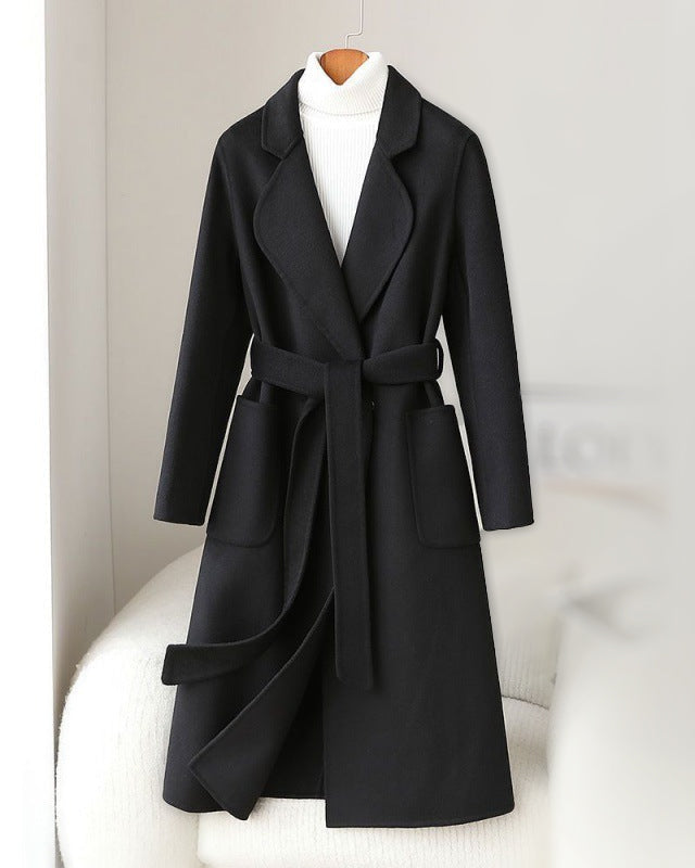 Elegant monochrome wool coat with waist belt by Lumina Wear, featuring a tailored fit and classic design.