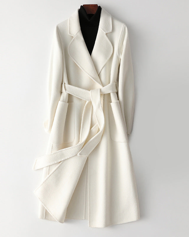 Elegant monochrome wool coat with waist belt, designed by Lumina Wear, featuring a tailored silhouette and classic style.