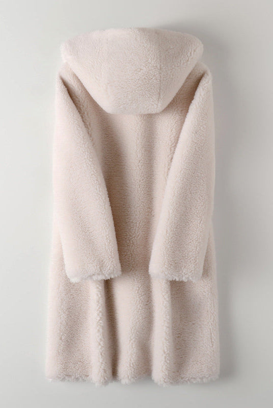 Lumina Wear Sofia plush oversized teddy coat with hood, large buttons, soft texture, worn by a woman outdoors.