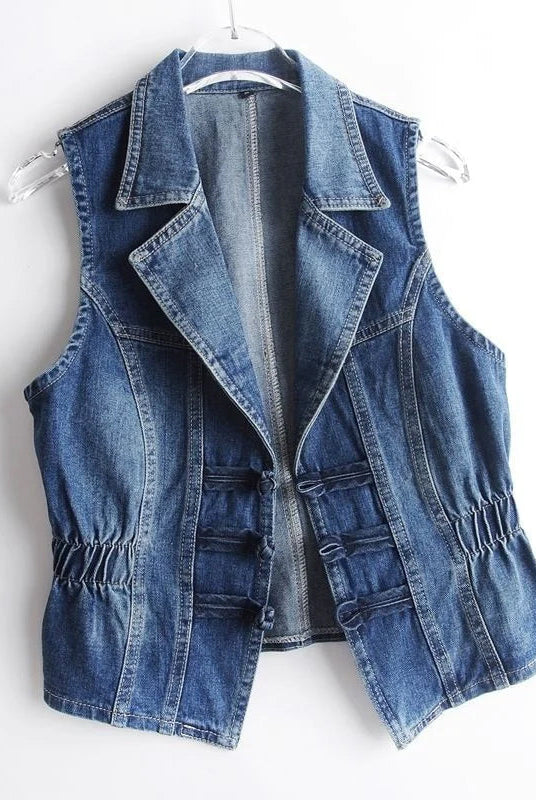 Valentina Celestial medium blue washed denim vest with toggle fastenings by Lumina Wear, displayed on a hanger.