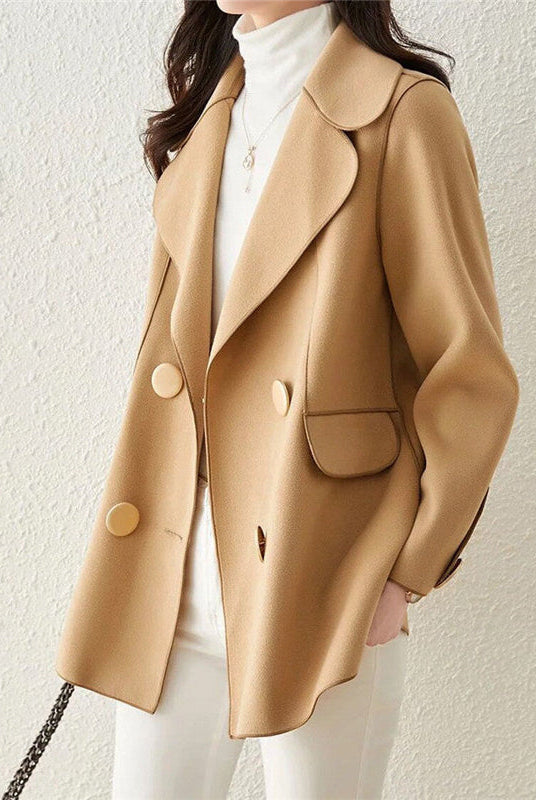Elegant double-breasted wool coat with structured lapels by Lumina Wear, modeled on a woman standing outdoors in winter.