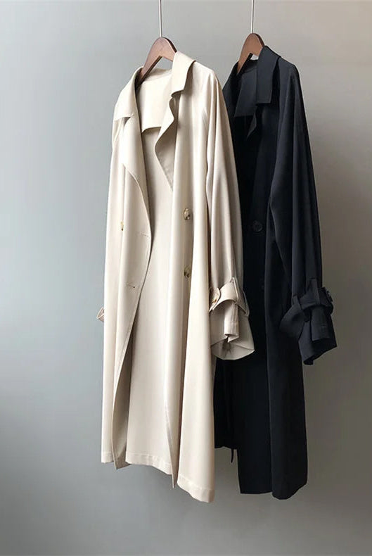 Elegant lightweight black trench coat with silky drape from Lumina Wear, styled on a woman showcasing its sleek design.