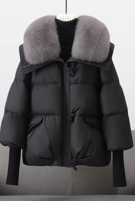 Extended-length black puffer jacket with fur collar from Lumina Wear, featuring a stylish design and warm, padded insulation.