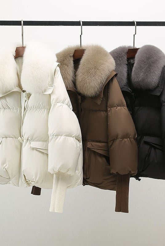 Black extended-length puffer jacket with fur collar from Lumina Wear, featuring a cozy, padded winter design.