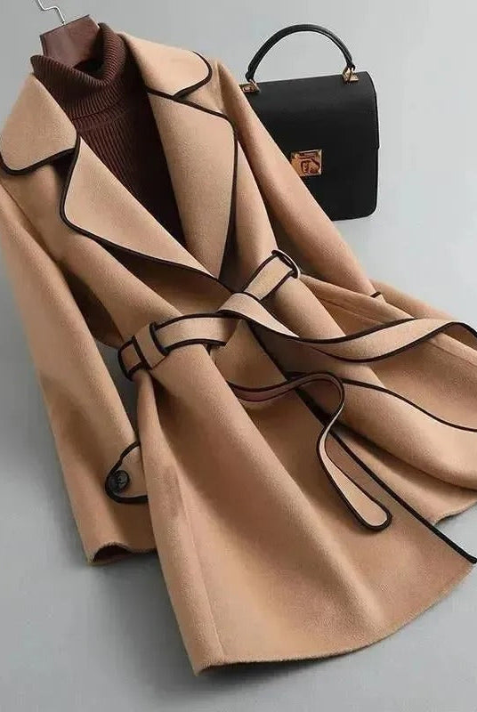 Elegant black trench coat by Lumina Wear featuring contrast piping, stylish long coat with classic silhouette and button details.