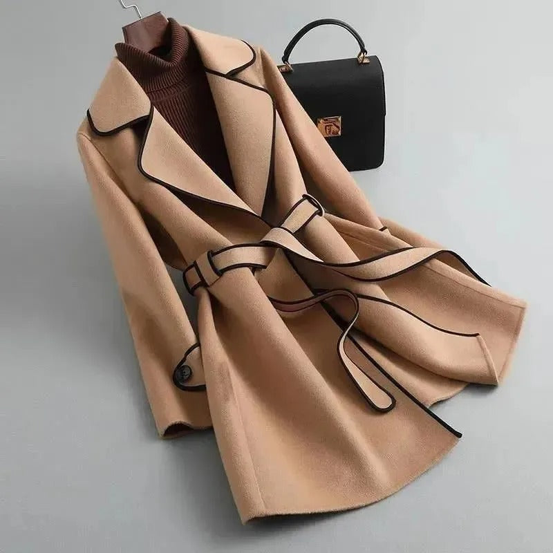 Elegant black trench coat by Lumina Wear featuring contrast piping, stylish long coat with classic silhouette and button details.