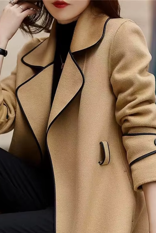 Black trench coat with contrast piping from Lumina Wear, featuring a tailored silhouette and stylish design details.
