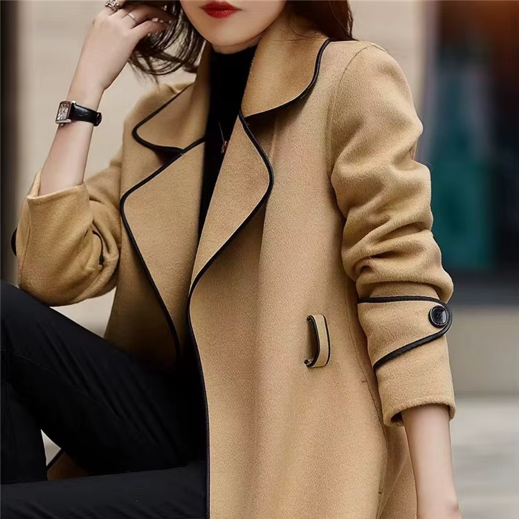 Black trench coat with contrast piping from Lumina Wear, featuring a tailored silhouette and stylish design details.