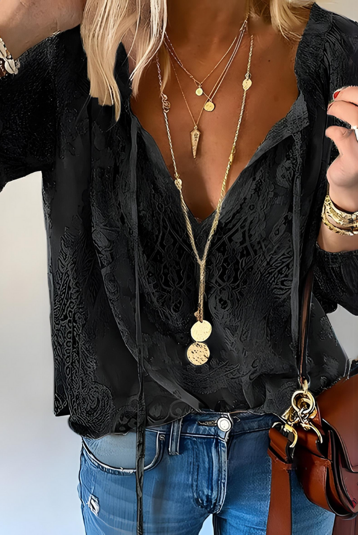 Victoria Lumina bohemian V-neck blouse with decorative detailing, featuring elegant design and flowing fabric.