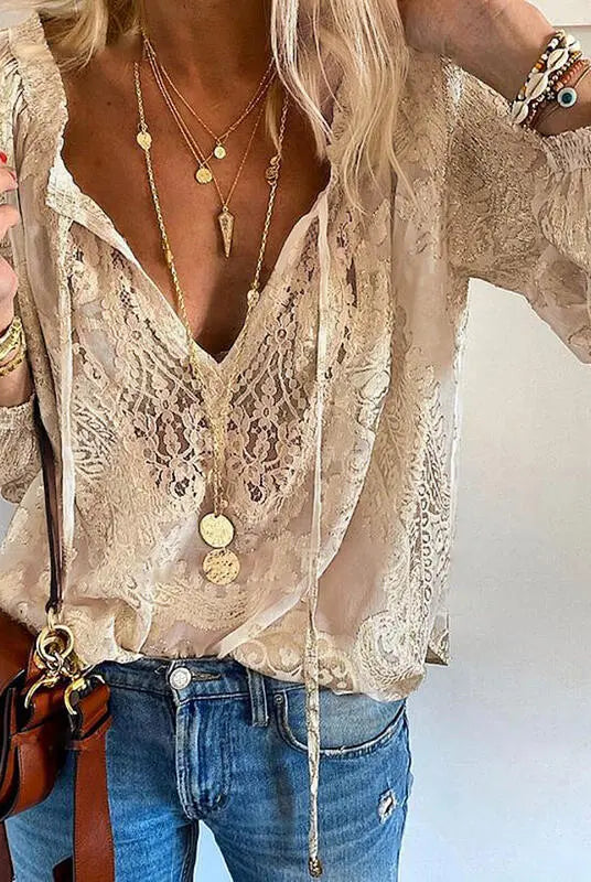 Victoria Lumina bohemian V-neck blouse with decorative detailing, featuring flowing fabric and intricate embellishments.