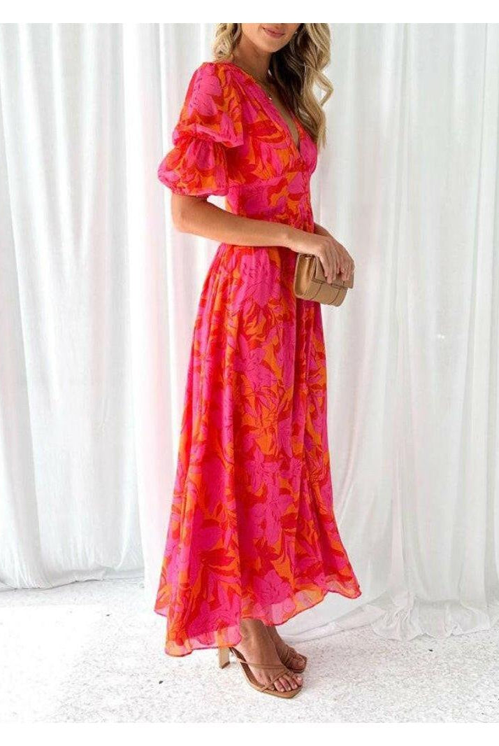 Red and pink Lumina Wear Alva elegant V-neck puff sleeve maxi dress displayed on a model, showcasing its flowing design.