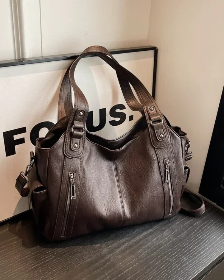 Black Lumina Wear handbag with amber accents, elegant shoulder bag featuring a functional design and stylish appearance.